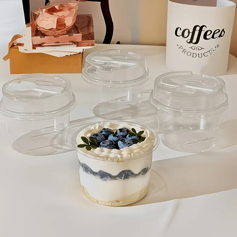 A glass dessert cup filled with white cream and blueberries, set against a white background.