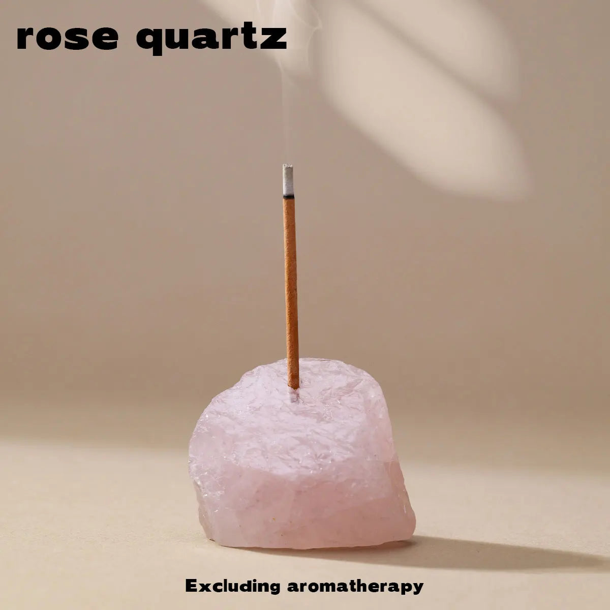 A pink rose quartz crystal is shown with a stick of incense burning on top.
