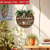 A round wooden sign with the text welcome to our home decorated with greenery and a bow.