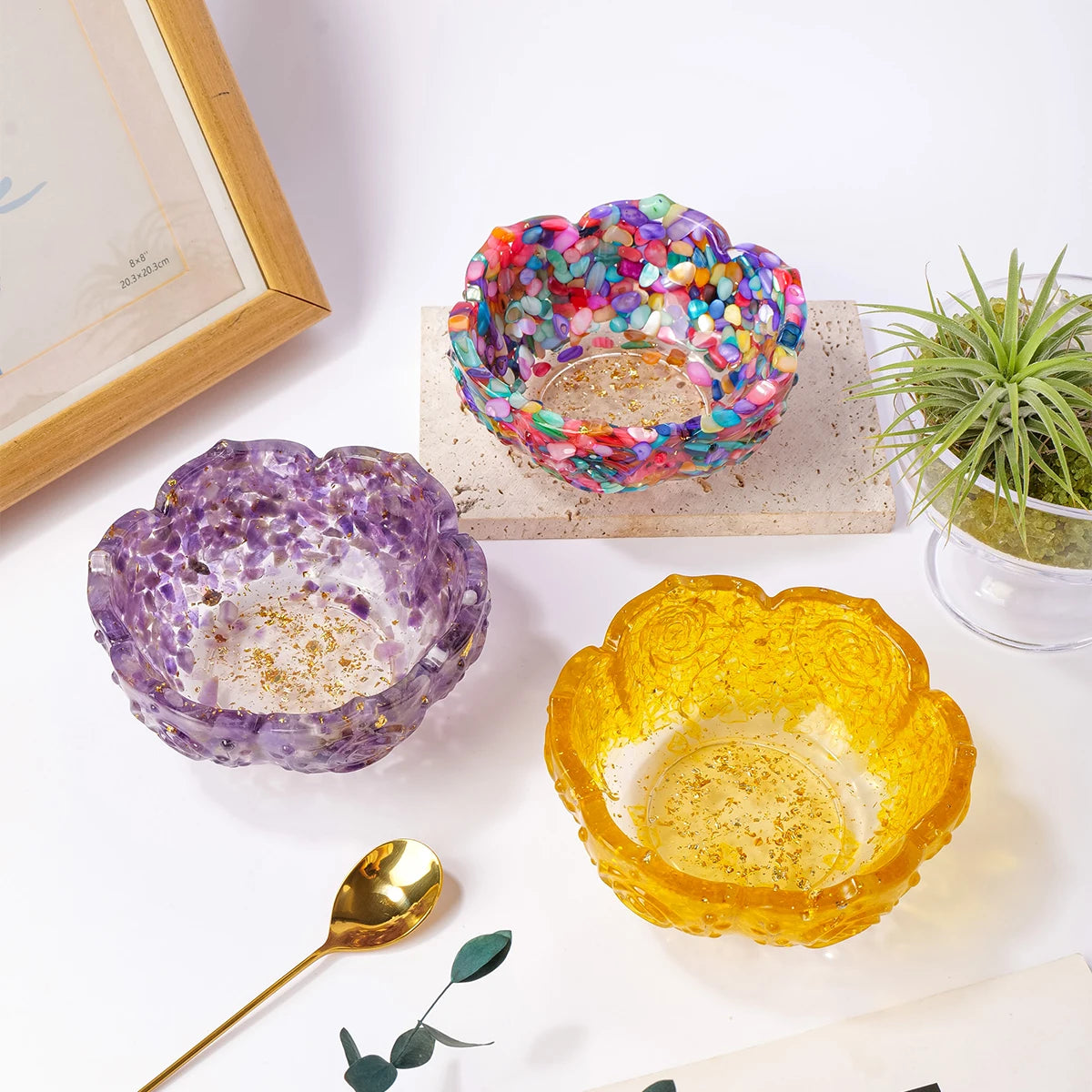 A collection of colorful crystal lotus bowls, including a multi-colored bowl and an orange one, displayed on a white surface.