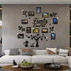 A modern living room wall decorated with a family tree photo collage featuring framed pictures and leaves.