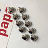 A collection of silver heart-shaped fridge magnets arranged in a row.