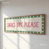 A framed canvas print featuring the text SHOES OFF PLEASE in pink lettering on a light background with green borders.