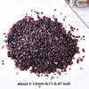A pile of deep burgundy natural garnet crystal chips for jewelry and decor.