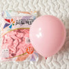 A single, large pastel pink latex balloon is shown next to a package of pink tissue paper balloons.