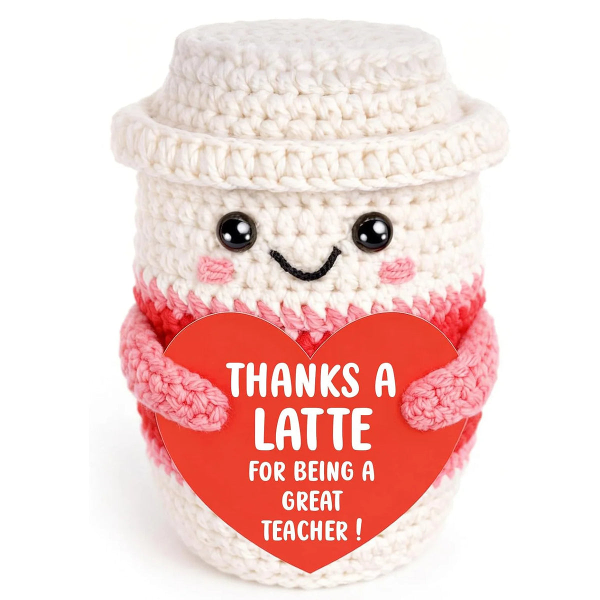 Handwoven knitted coffee cup cozy with a smiling doll decoration in white and pink yarn.