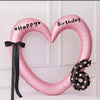 Pink heart-shaped balloon decoration with Happy Birthday text and a black six on a white background
