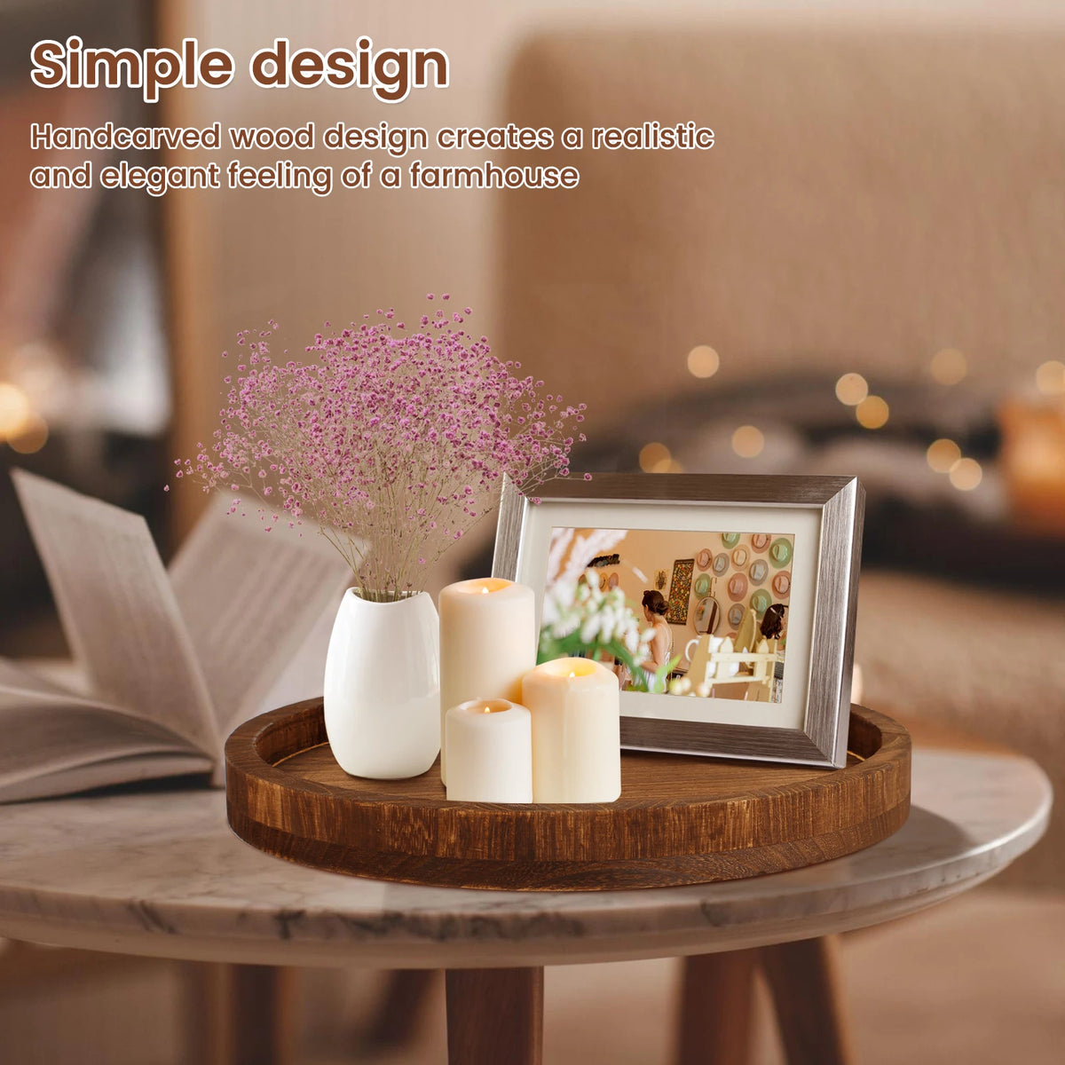 A handcrafted wooden serving tray holds white candles and a small floral arrangement in a warm indoor setting.