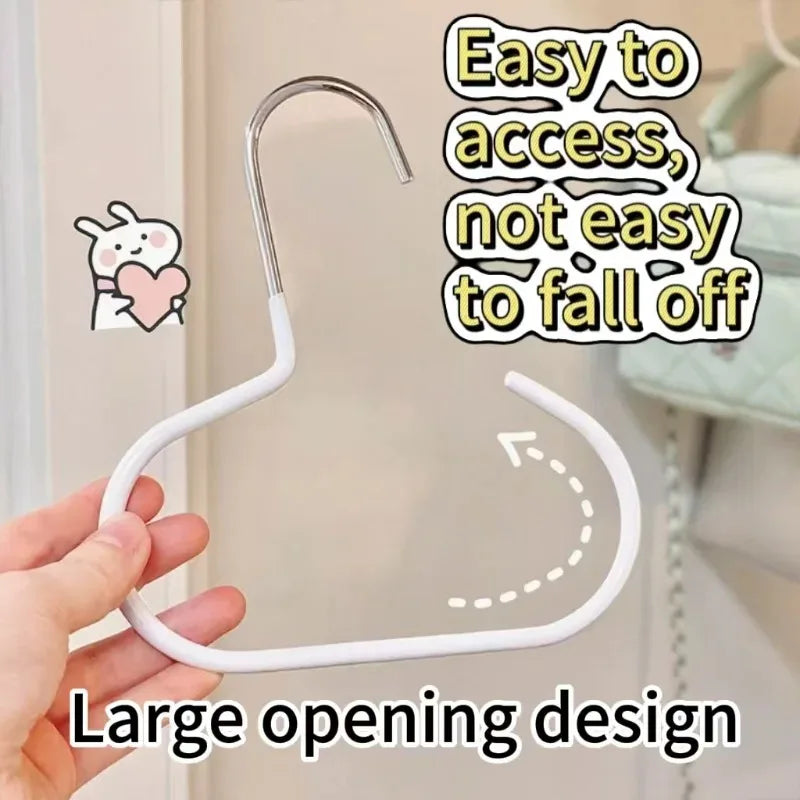 A hand is holding a white, curved hat organizer rack with an easy-to-access design.