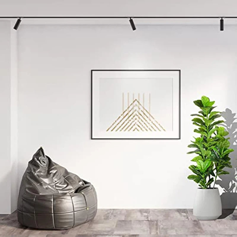 A potted artificial fiddle leaf fig tree in a white pot displayed on a modern interior wall.