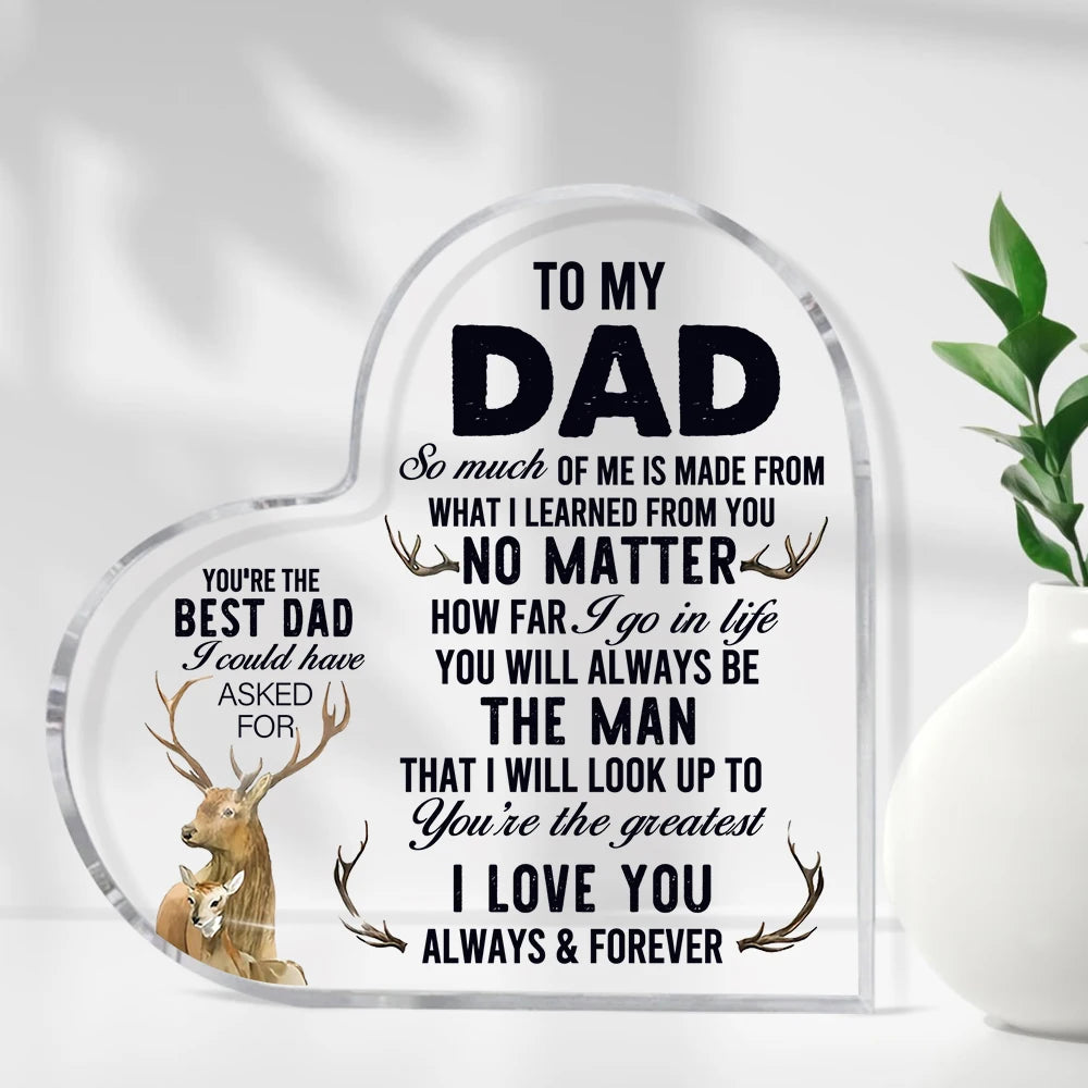 A clear glass heart-shaped sign with engraved text for a father, featuring deer antlers and loving messages.
