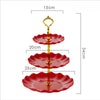 A three-tier red plastic dessert stand with gold accents, featuring three ruffled plates.