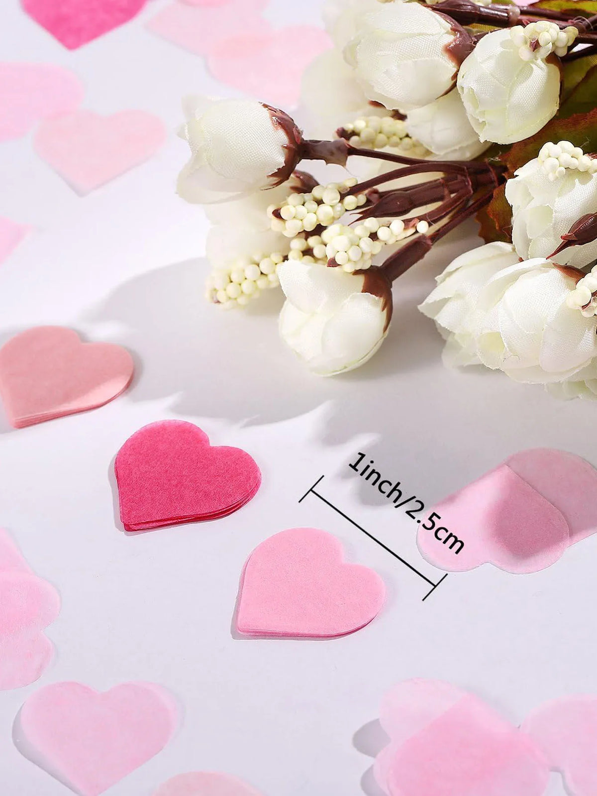 White and pink floral arrangement with heart-shaped sequins confetti
