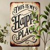 A rustic iron wall sign with carved text that reads This Is My Happy Place, mounted on a light-colored wall.