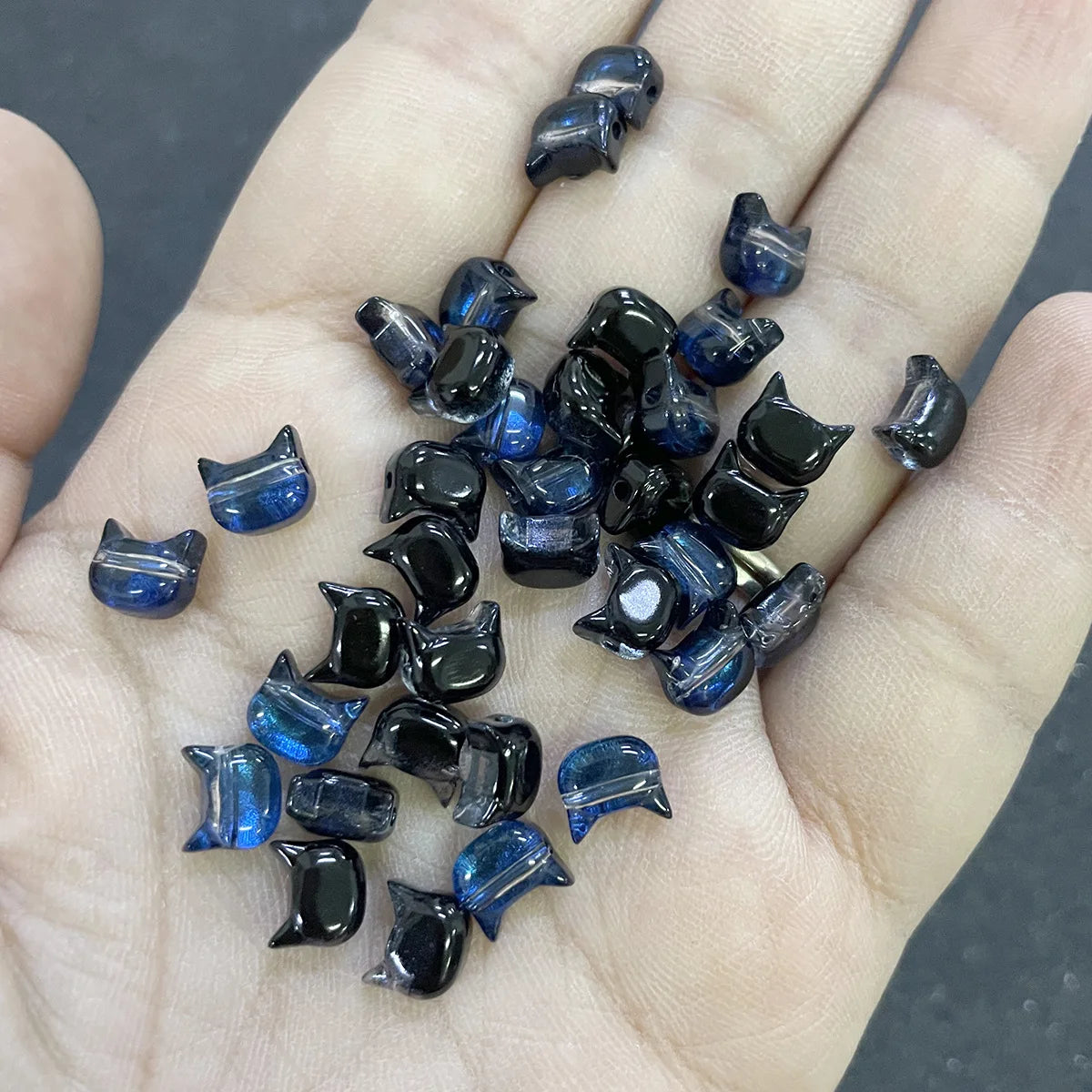 A handful of dark blue and black cat head glass beads for jewelry making