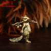 A vintage brass squirrel figurine standing on a dark wooden surface.