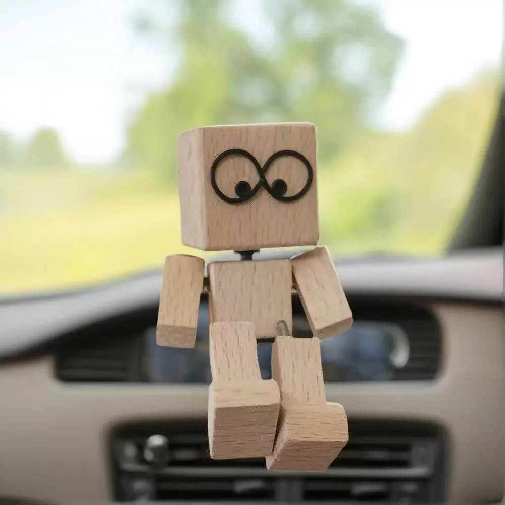Petite figurine en bois avec un symbole d'infini sculpté sur son visage, placée sur le tableau de bord d'une voiture.