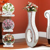 Tall silver mirrored vase with a crushed diamond finish holding fresh flowers.