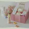 A pink box contains a candle, a gold ring, and floral elements for aromatherapy candles.
