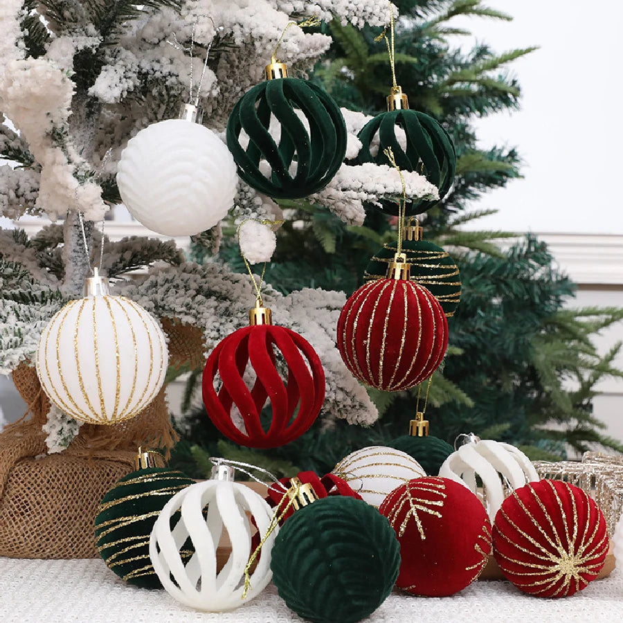 A collection of velvet Christmas tree hanging ornaments in shades of green, red, and white are displayed on a snowy evergreen
