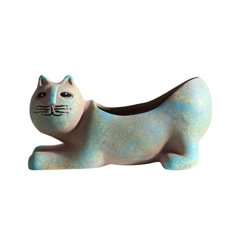 A ceramic succulent planter shaped like a cat, colored in iridescent blue and green tones.