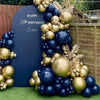 A navy blue and gold metallic balloon garland arch display against a dark slate background.