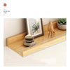 A natural wood floating shelf displaying a potted succulent and a wooden bird figurine.