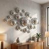 A collection of silver disco balls mounted on a light gray wall above a wooden cabinet.