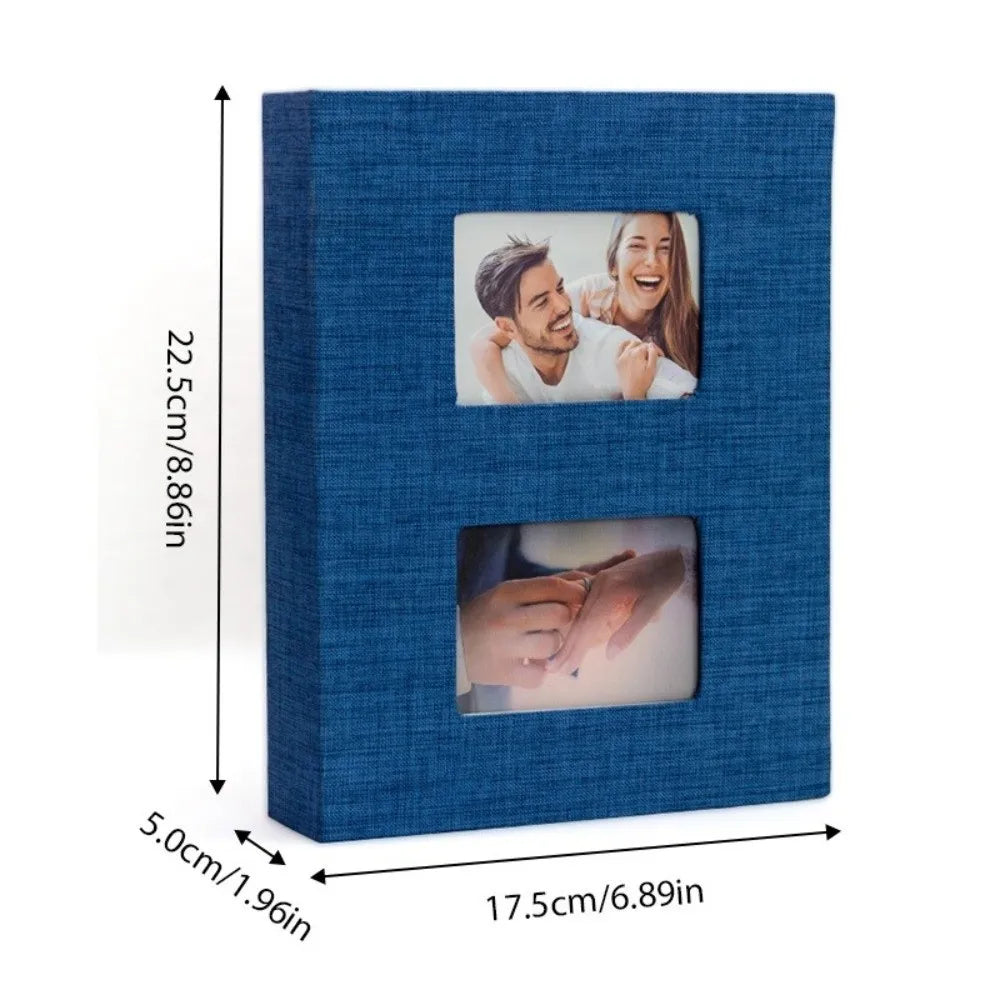 A blue linen-cover photo album with a rectangular window displaying a couple's portrait.