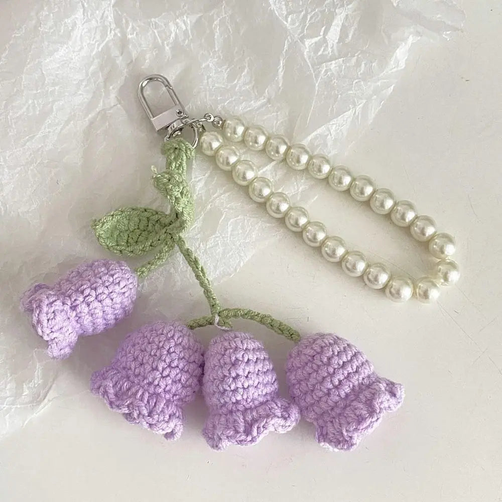 Handmade pearl chain orchid key ring featuring purple crocheted flowers and green leaves