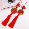 Red silk tassels with gold knot decor and a pink framed photo