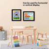Three framed art pieces displayed on a wooden table with small stools and magnetic art supplies