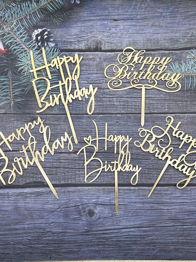 Gold acrylic birthday cake toppers with happy birthday lettering on a dark wooden background