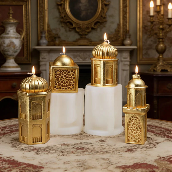 A set of gold and white silicone candle molds shaped like mosque domes and minarets displayed on a table.