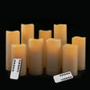 A set of four glowing amber LED candles and two remote controls are displayed against a black background.