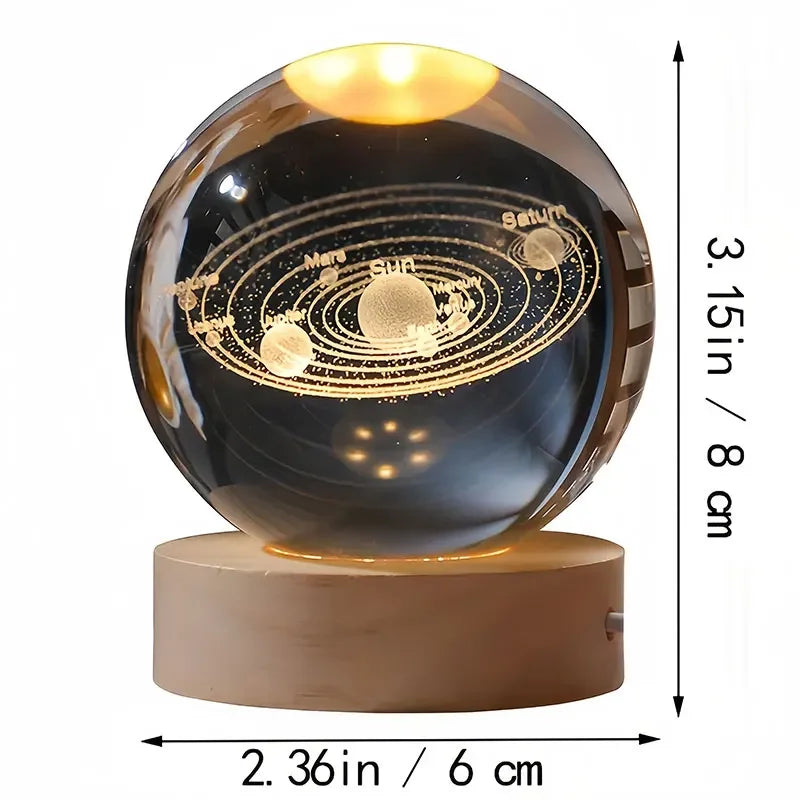 A spherical glass decoration featuring a solar system engraved on its surface.