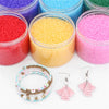 Assortment of colorful frosted glass rice beads and a bracelet with dangling earrings for jewelry making