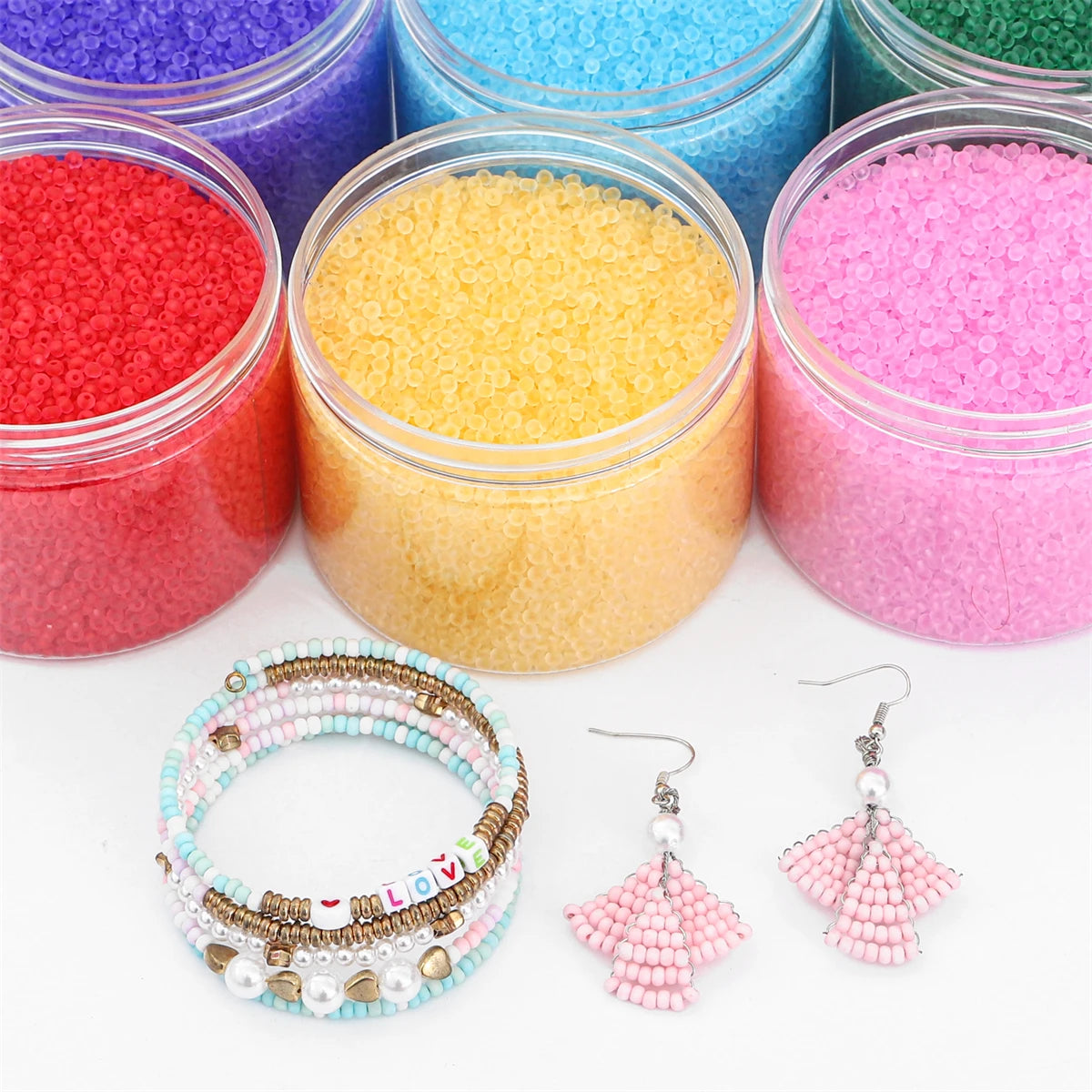 Assortment of colorful frosted glass rice beads and a bracelet with dangling earrings for jewelry making