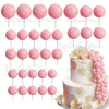 A set of pink foam cake toppers, including various sizes and shapes, arranged for decoration.