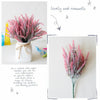 A bouquet of pink and purple lavender flowers in a white vase with a gold ribbon.