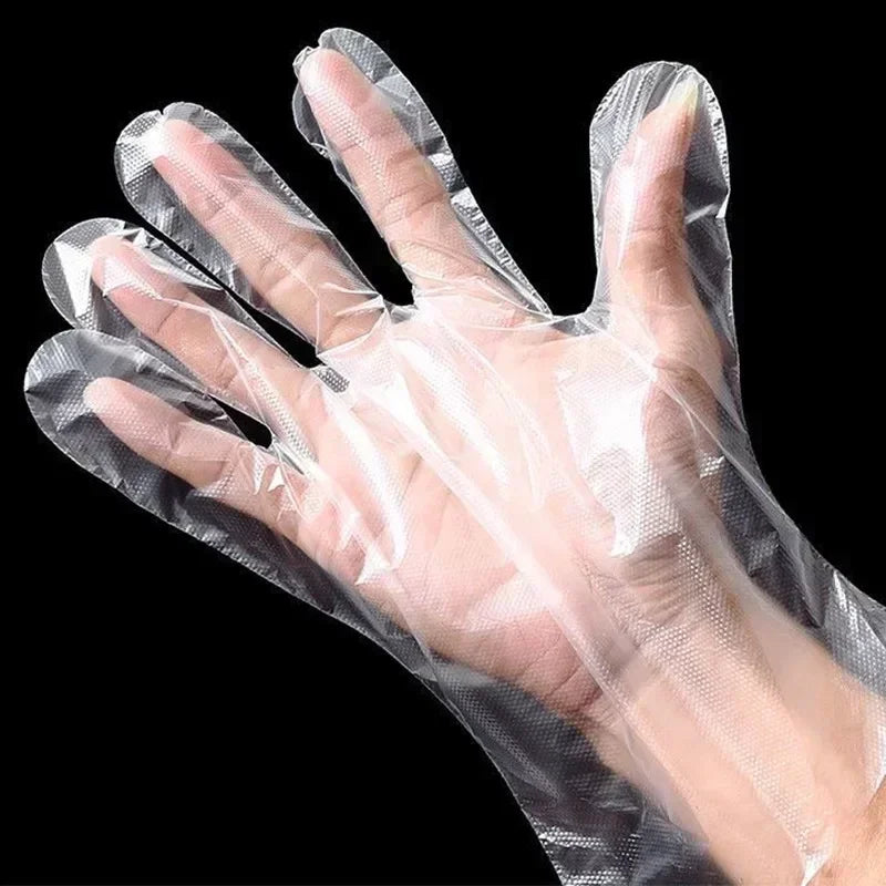 A hand wearing a clear disposable plastic glove for kitchen and food preparation.