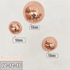 Three rose gold disco balls of different sizes are displayed on a white background.