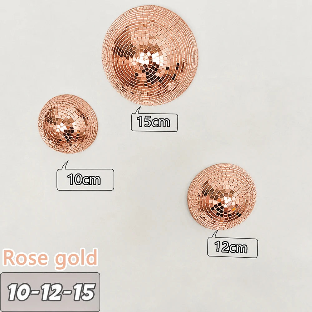 Three rose gold disco balls of different sizes are displayed on a white background.