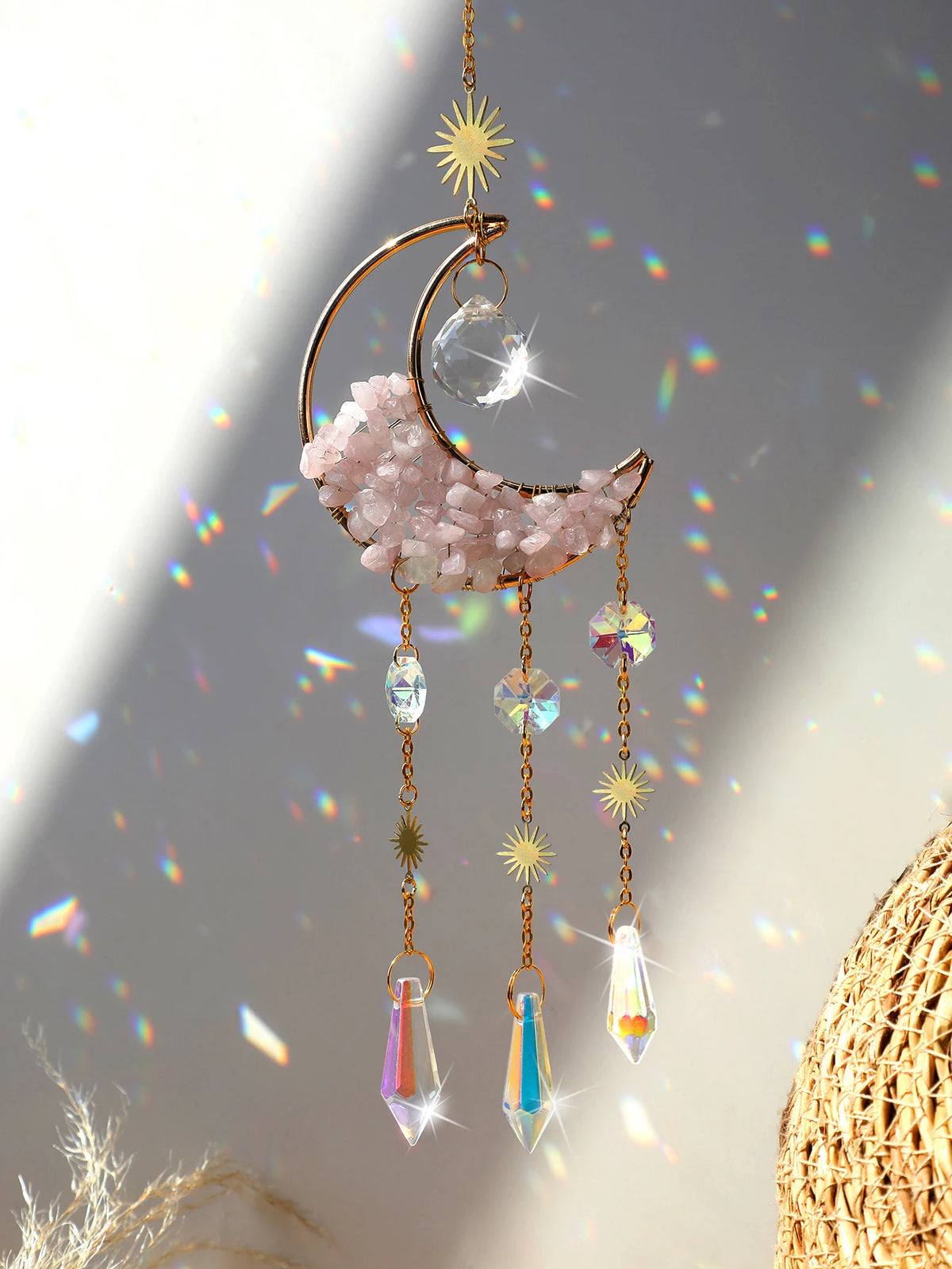 A handcrafted moon crystal suncatcher featuring a pink crescent moon and dangling prism pendants.