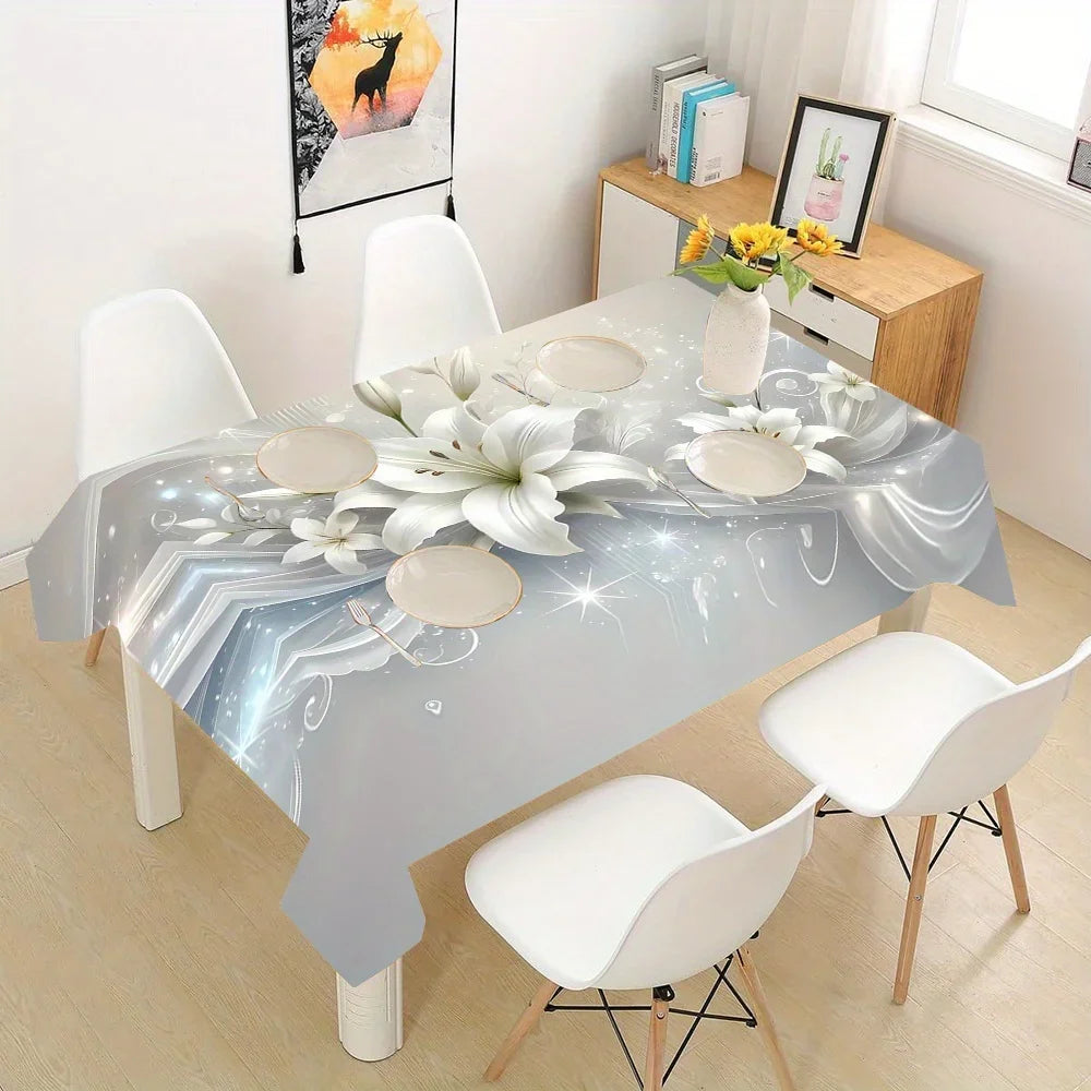 A rectangular table set for dining with a silver and white floral tablecloth, surrounded by white chairs.