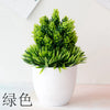 Un vibrant plant de bonsaï artificiel vert dans un pot blanc, posé sur une surface claire.
