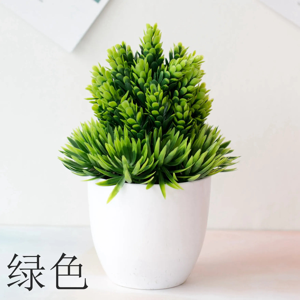 Un vibrant plant de bonsaï artificiel vert dans un pot blanc, posé sur une surface claire.