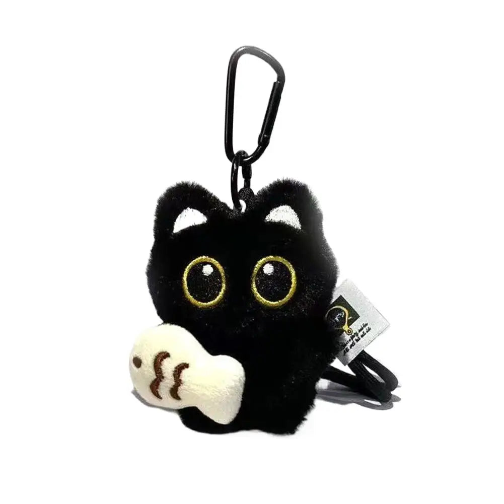 A black seal plush keychain with gold eyes and a white snout.