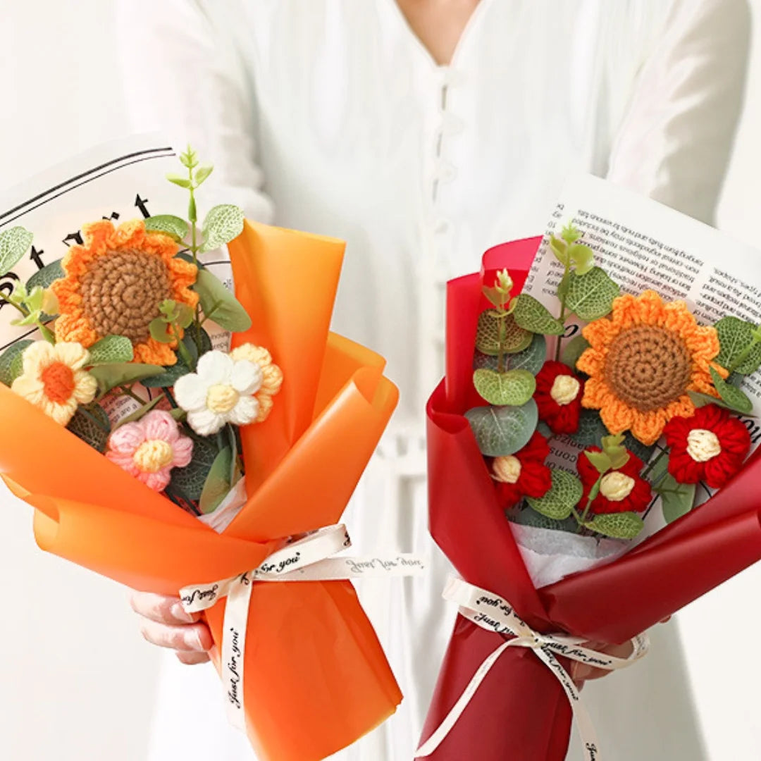 A bouquet of handcrafted crochet sunflowers in orange and red colors wrapped in red paper
