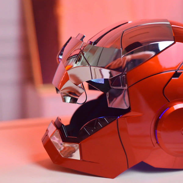 A close-up of an Iron Man MK5 wearable helmet in metallic orange and silver, resting on a light surface.
